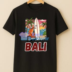 Kaos Souvenir Bali hitam bergambar skuter klasik, surfboard, dan sunset pantai—gaya liburan yang bikin orang mengira kamu habis dari Bali.
